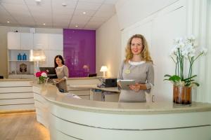 a woman standing at a counter in an office at Hotel Mon Cheri in Riccione