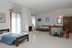a room with two beds and a table and a fireplace at Eri Hotel in Parikia