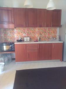 uma cozinha com armários de madeira e uma bancada de cozinha em "Apartment 2" em Lerápetra