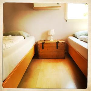 a room with two beds and a table with a lamp at De Munnik in Camperduin