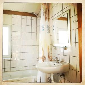 a bathroom with a sink and a mirror and a tub at De Munnik in Camperduin +22 photos