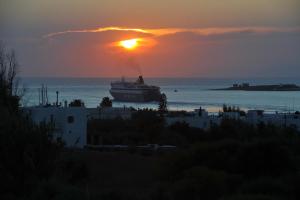 a cruise ship in the ocean at sunset at Eri Hotel in Parikia
