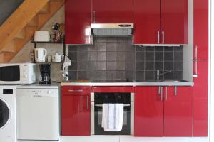 アゲにあるCap Esterel vue Merの赤いキャビネットと食器洗い機付きのキッチンが備わります。
