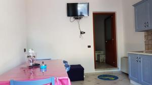 Lenolaにあるvilla del maestroのキッチン(テーブル付)、壁掛けテレビが備わります。