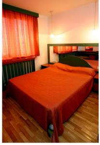 een rood bed in een kamer met 2 ramen bij Studio Pipo in Varna