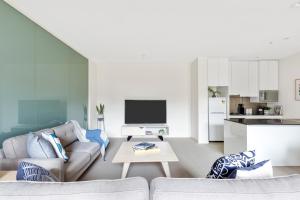 a living room with a couch and a table at Nook Melbourne Apartments : Collins Street - Melbourne CBD in Melbourne