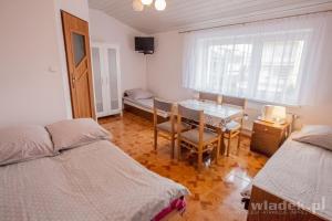 1 Schlafzimmer mit 2 Betten, einem Tisch und einem Esszimmer in der Unterkunft Pokoje Monika in Władysławowo