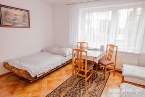 ブワディスワボボにあるPokoje Monikaのベッドルーム1室(ベッド1台、テーブル、椅子付)