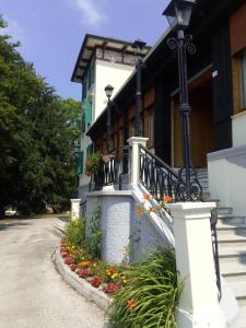 um edifício com uma varanda com flores na rua em Villa Paola em Lavarone