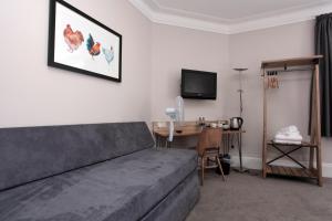 um quarto com uma cama, uma secretária e uma televisão em Bear Inn, Somerset by Marston's Inns em Street