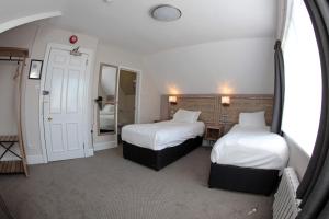 a hotel room with two beds and a mirror at Bear Inn, Somerset by Marston's Inns in Street +19 photos