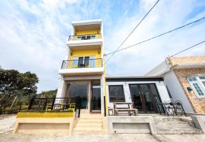 a house with a yellow and white at Tiffany Homestay in Eluan