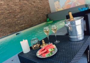 - une table avec des verres de champagne et une assiette de fruits dans l'établissement Maison Jules, à Sainte-Ode