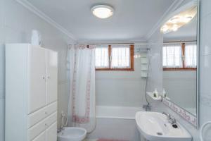Baño blanco con lavabo y aseo en Casa Pauli, en Colombres
