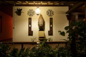 una habitación con una estatua en una pared con plantas en Terres Rouges Lodge en Banlung