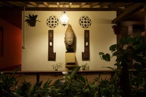 una habitación con una estatua en una pared con plantas en Terres Rouges Lodge, en Banlung