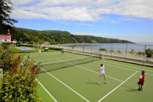 Eine Gruppe von Menschen spielt Tennis auf einem Tennisplatz in der Unterkunft Hotel Tadoussac in Tadoussac