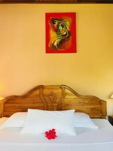 a bed with a red flower on top of it at Villa Source D'Argent in La Digue