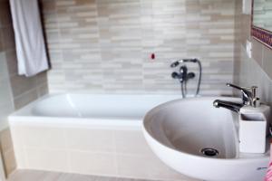 een badkamer met een wit bad en een wastafel bij casa andreana in Uri