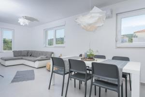 a white living room with a table and chairs at TiaMar in Slatine