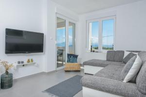 a living room with a couch and a flat screen tv at TiaMar in Slatine