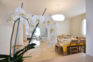 a dining room with a table and white flowers at Villa Luigia Luxury Relais in Gallipoli