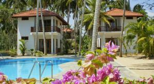 un resort con piscina e palme di Good Karma a Tangalle
