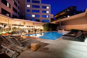 a swimming pool with lounge chairs and a building at Hotel SB Icaria in Barcelona