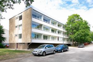 um edifício com dois carros estacionados em frente em Design Apartments Kristiina em Naantali
