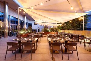 a restaurant with tables and chairs on a patio at Hotel SB Icaria in Barcelona