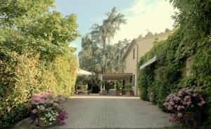 a brick walkway with flowers and a building at LAGO GABBIANO PODERe CASANOVA in Pistoia