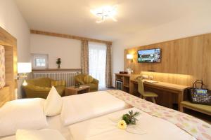 een hotelkamer met 2 bedden en een bureau bij Hotel Chrysantihof in Bad Birnbach