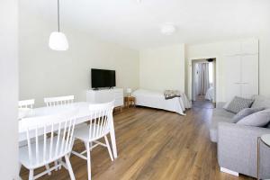 a white living room with a table and a couch at Design Apartments Kristiina in Naantali