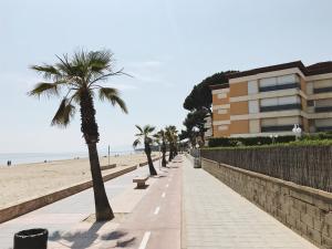 una acera junto a una playa con palmeras y un edificio en Ca La Bet, en Cambrils