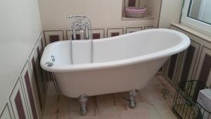 a white bath tub in a bathroom with a window at L'OBSIDIENNE in Lixheim