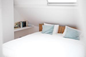 リールにあるDO-DO te Lierのベッドルーム1室(白いシーツと青い枕のベッド1台付)