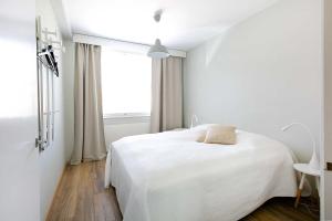 um quarto branco com uma cama branca e uma janela em Design Apartments Kristiina em Naantali