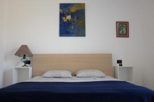 Schlafzimmer mit einem Bett mit blauer Decke in der Unterkunft La Strelitzia Cervo Mare in Cervo