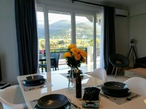 a dining room table with a vase of flowers on it at Mirador Apartments in Limenas