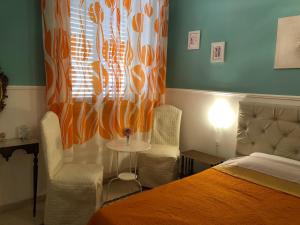sypialnia z łóżkiem i dwoma krzesłami oraz oknem w obiekcie B&B Mariupol w Trapani