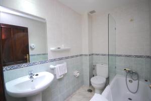 een badkamer met een wastafel, een toilet en een douche bij Hotel Los Ángeles in Arenas de Cabrales