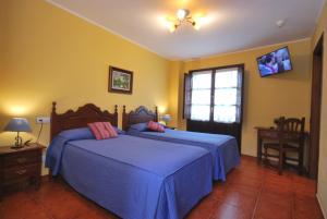 1 dormitorio con 2 camas con sábanas azules y ventana en Hotel Los Ángeles, en Arenas de Cabrales 14 fotos más