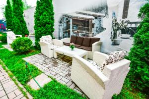 a patio with white chairs and a coffee table at Terra Nova Sport&Spa Hotel in Hatne