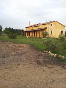 Massama的住宿－Affittacamere Luti，前面有一条土路的大房子