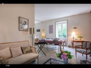 a living room with a couch and a table at Maison de charme 1930 proche Lyon in Lentilly