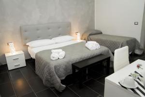 a hotel room with two beds with towels on them at B&B Napoli Binario 1 in Naples