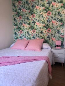 a bedroom with a bed with a floral wallpaper at coblanca 5 in Benidorm
