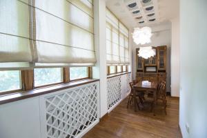 a dining room with windows and a table at Art Apartment in Tashkent