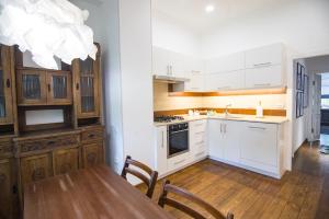 a kitchen with white cabinets and a table with chairs at Art Apartment in Tashkent