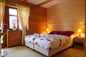 ムロンゴヴォにあるZakątek nad Junemのベッドルーム1室(木製の壁と窓のあるベッド1台付)